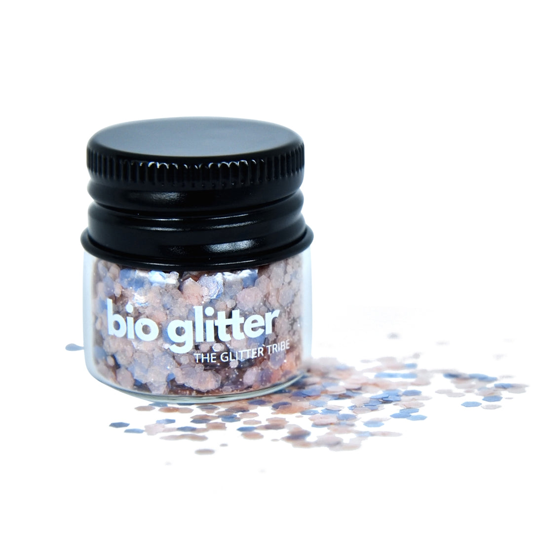 Blue and pink bio glitter in a glass jar with a black lid on a white background.