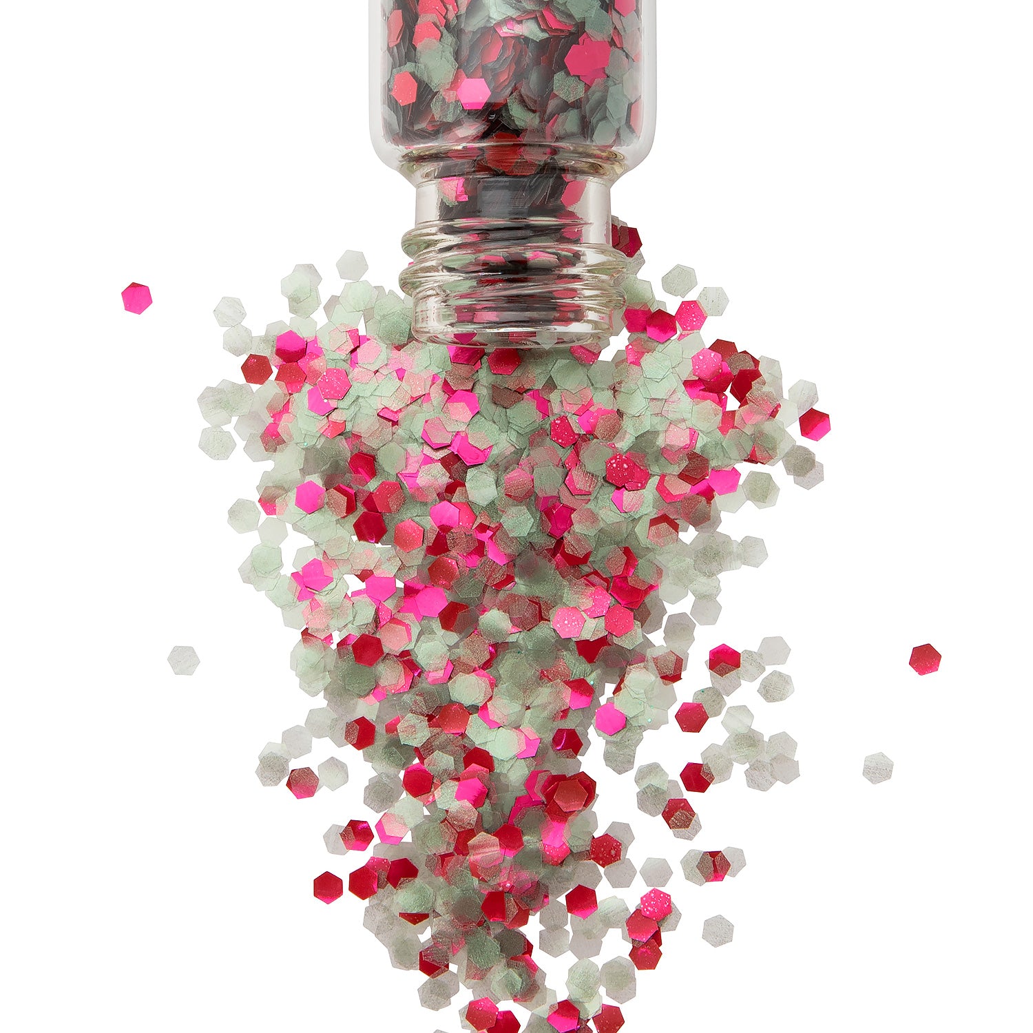 Christmas coloured chunky biodegradable glitter in a glass jar spreading out onto a white background.