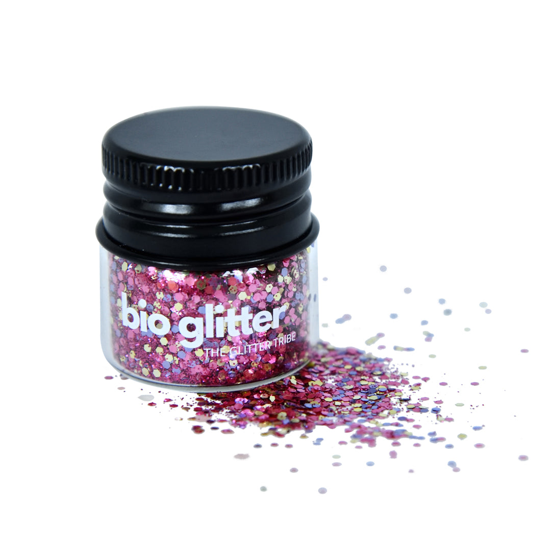 Bio glitter in a jar with a black lid. The glitter is purple with gold and purple sparkles