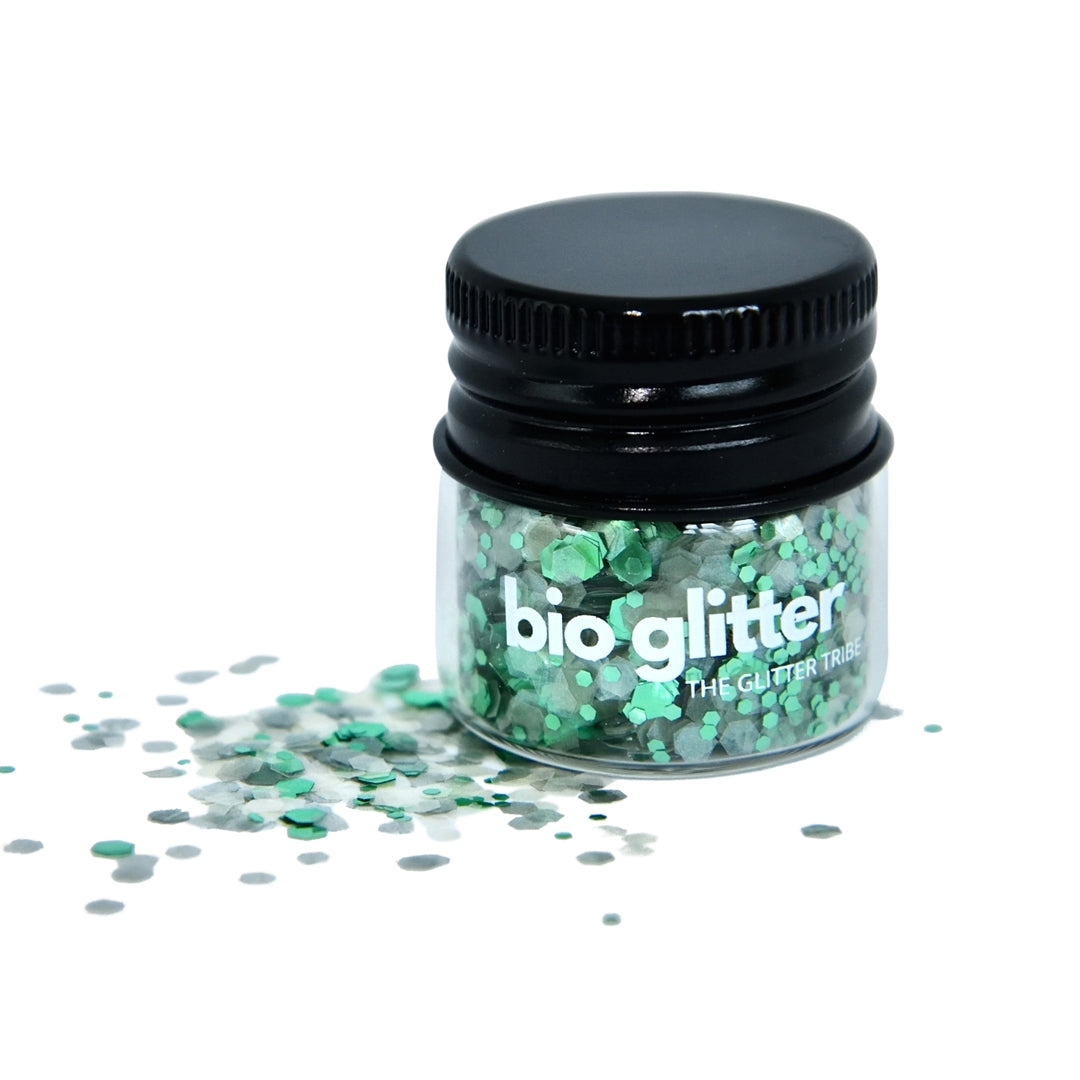 Green and clear glitter in a jar on a white background