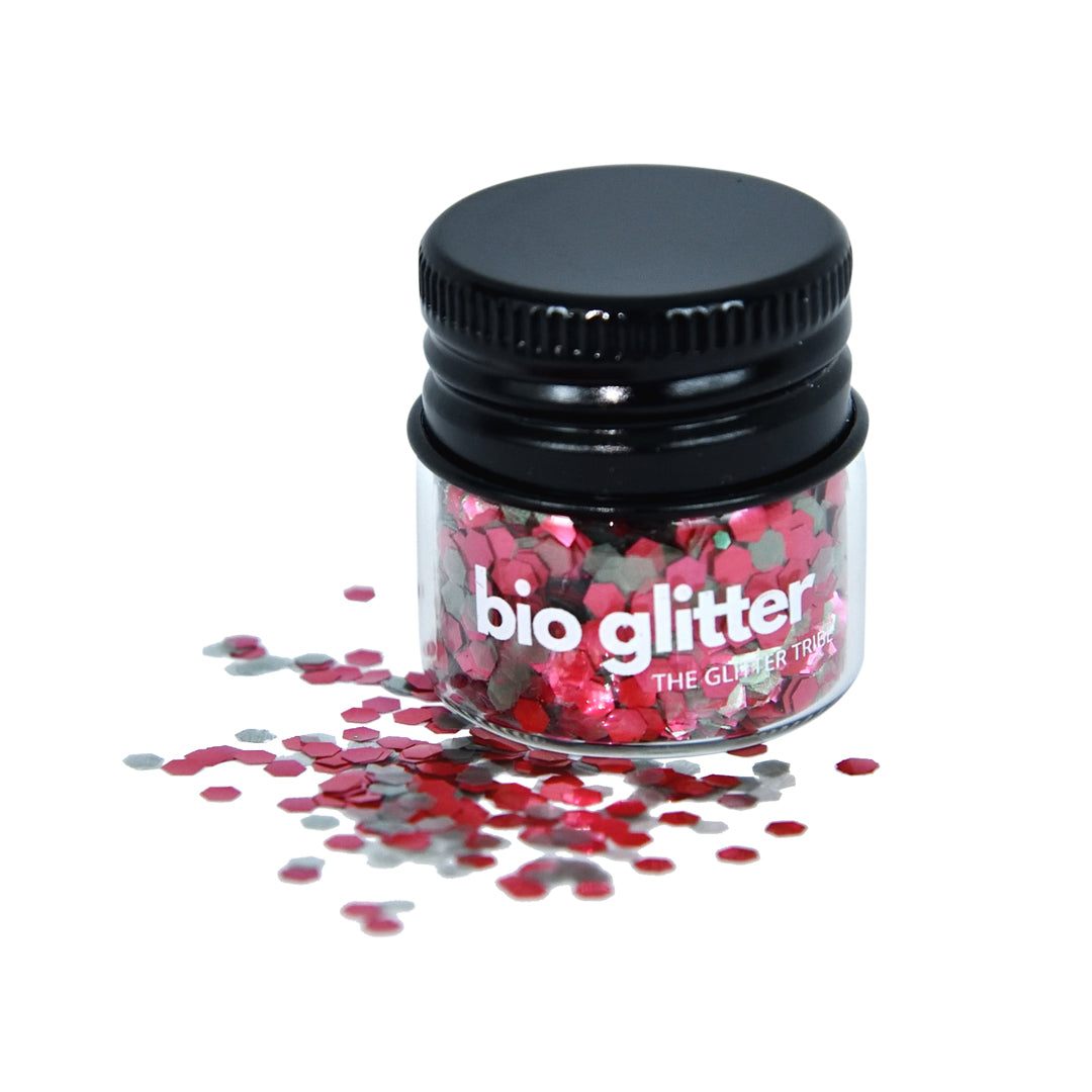 Christmas coloured chunky bio glitter in a jar with a black lid on a white background .