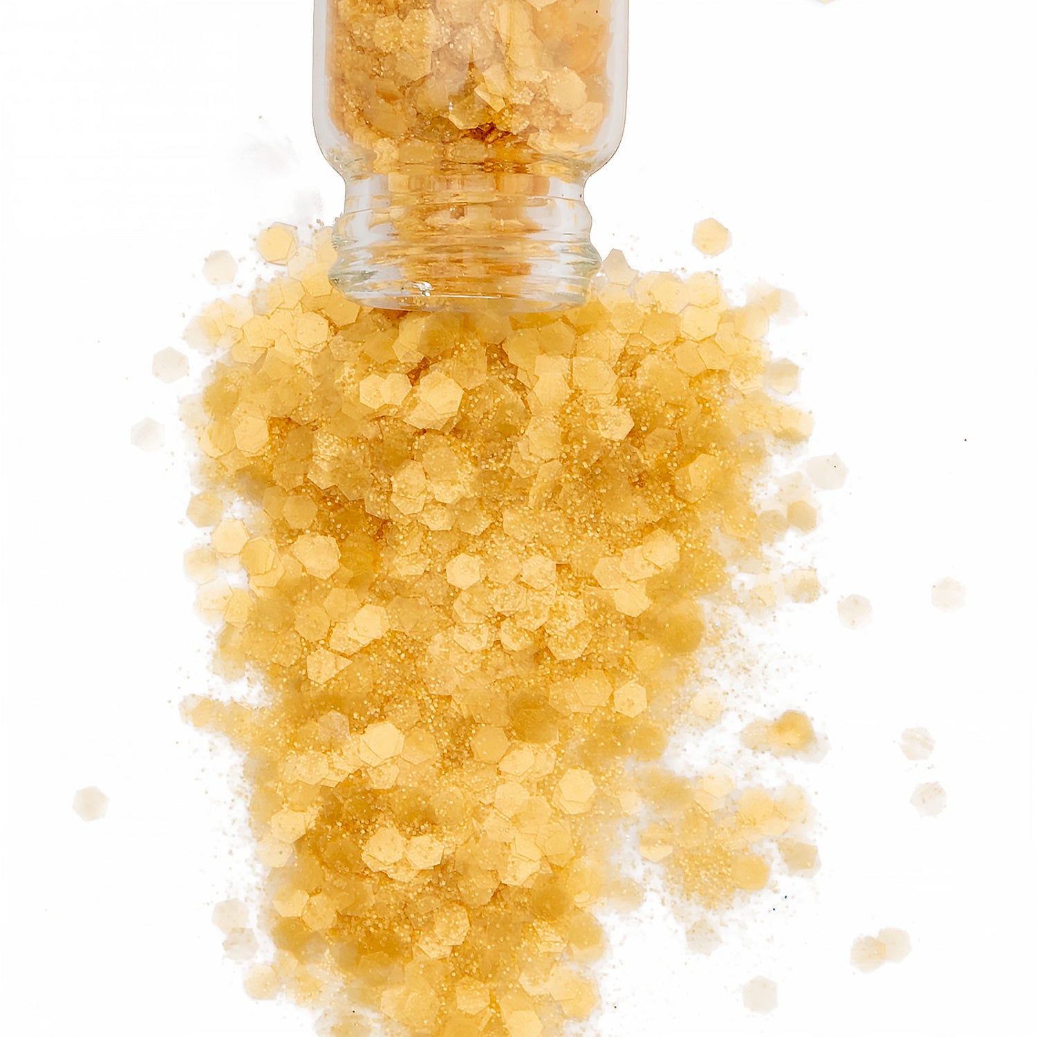 Yellow biodegradable glitter in a glass jar spilling onto a white backround.